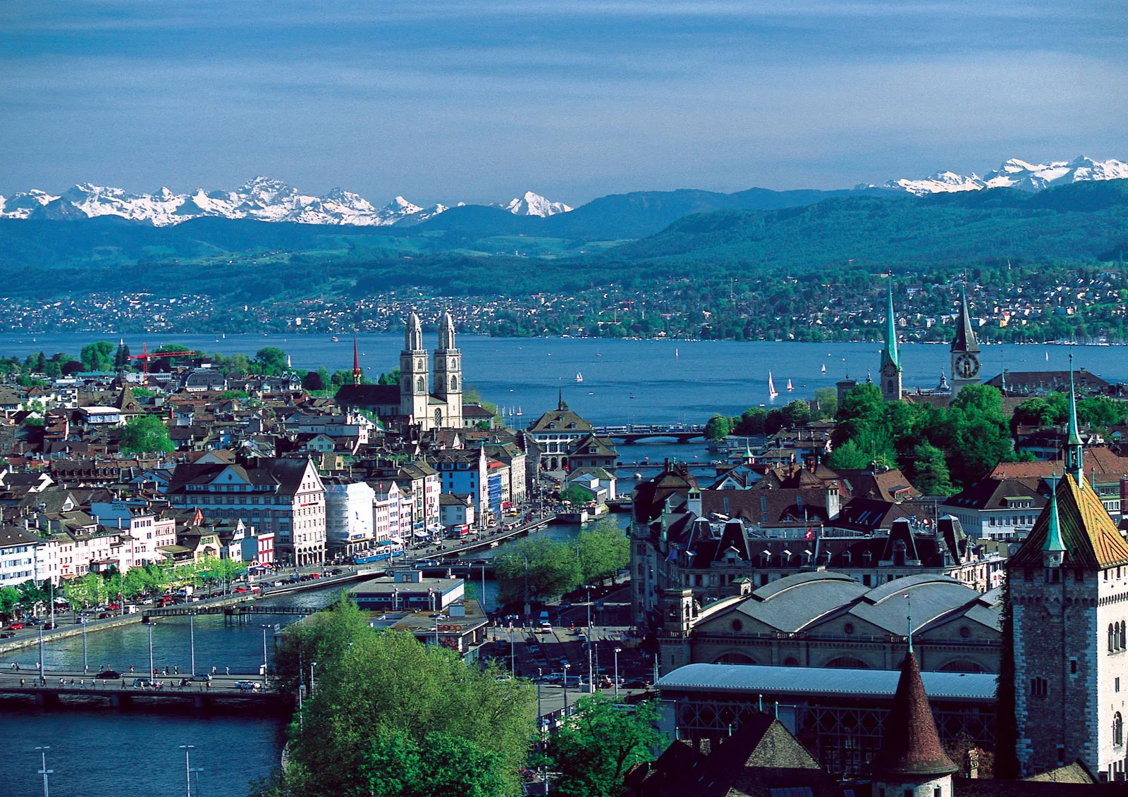 A view of Zurich and its lakes, with a snow-capped mountain in the background.